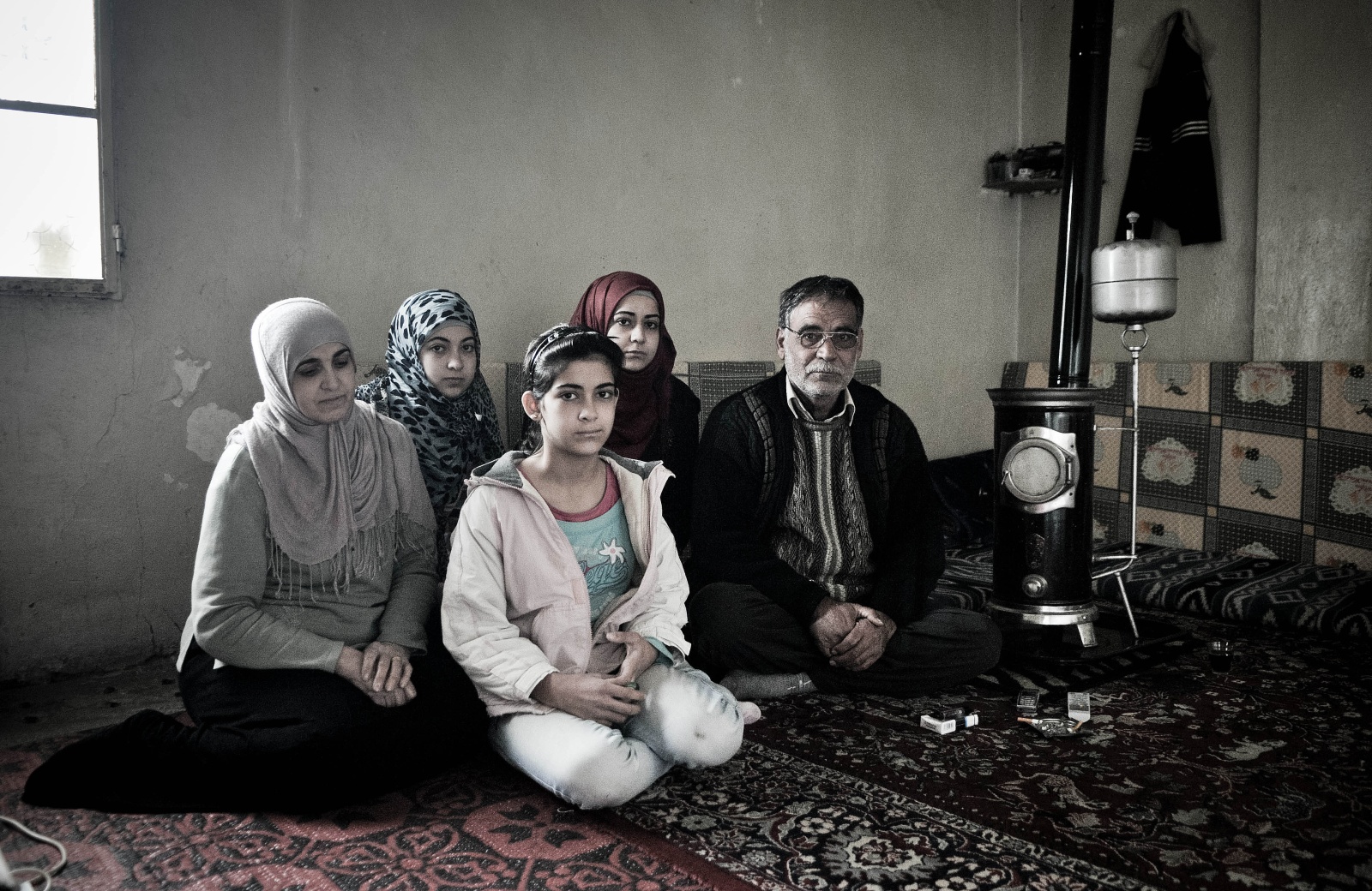 Aarsal - La famiglia di Najad.
Najad ha 24 anni e viene da Homs, una delle città più martoriate dalla guerra siriana.
Quando il padre ha preso la decisione di lasciare la città, e di recarsi ad Arsaal per sfuggire alla guerra, le ha raccomandato di non prendere troppa roba con sé, " Si tratterà di un mese o due, ritorneremo presto a casa".
Questo succedeva nel gennaio del 2012, e dopo un anno la famiglia di Najad si trova ancora in Libano, nella stessa casetta fatta di due stanze e un bagnetto fuori dal cortile. 